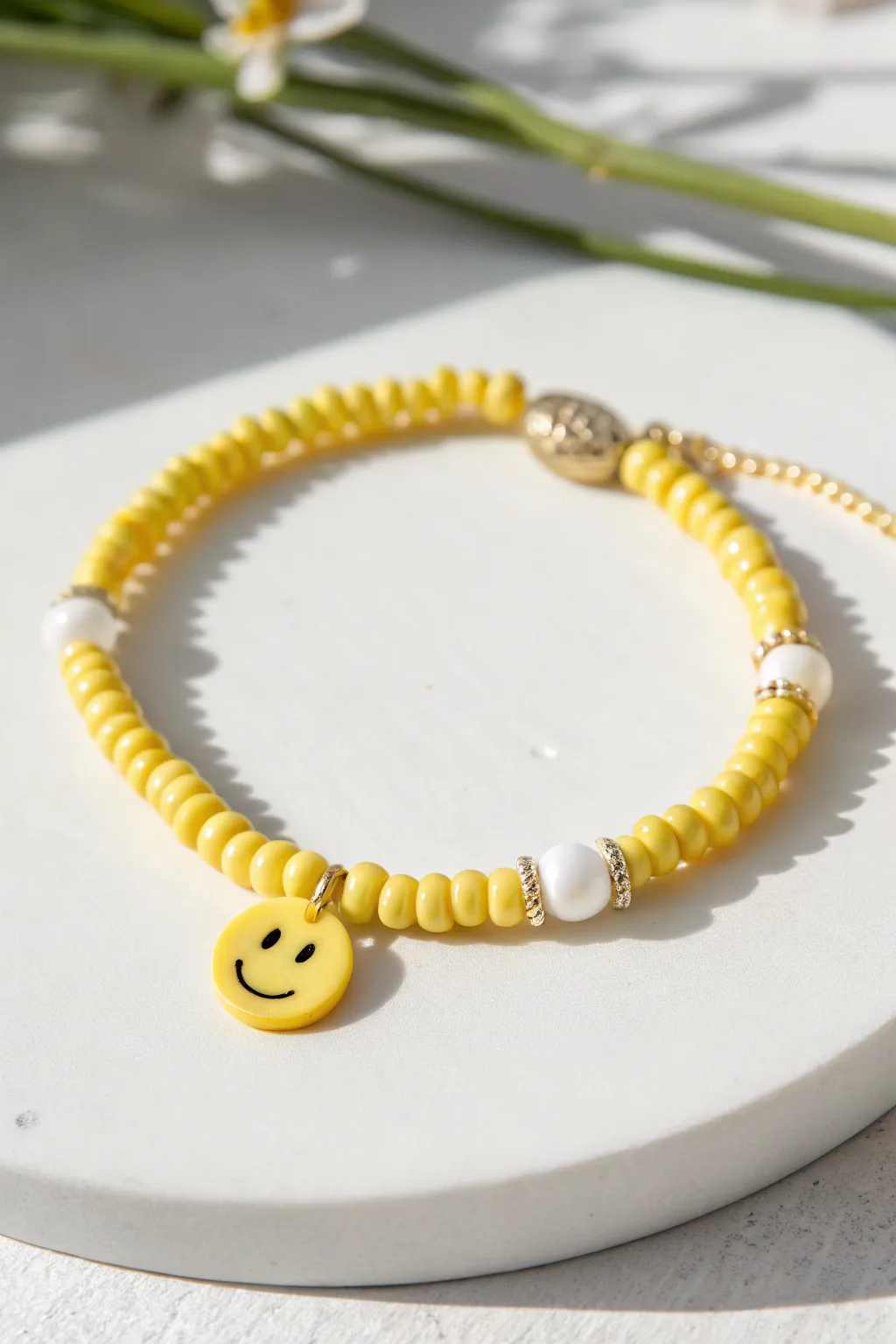 Sunny yellow heishi bracelet with a simple smiley accent and clean white spacers