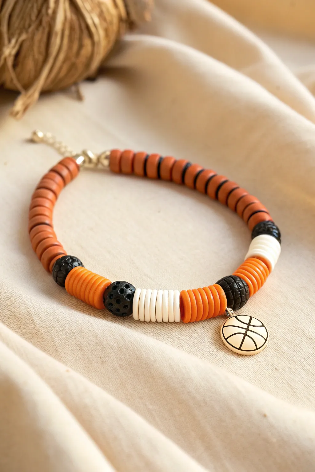 Orange and black heishi rhythm with a crisp white break and tiny basketball bead for subtle sport charm.