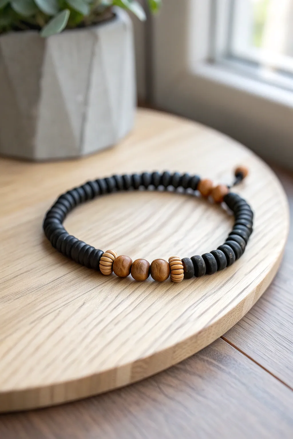 Matte black heishi beads with warm wood accents for a cozy, minimalist bracelet look.