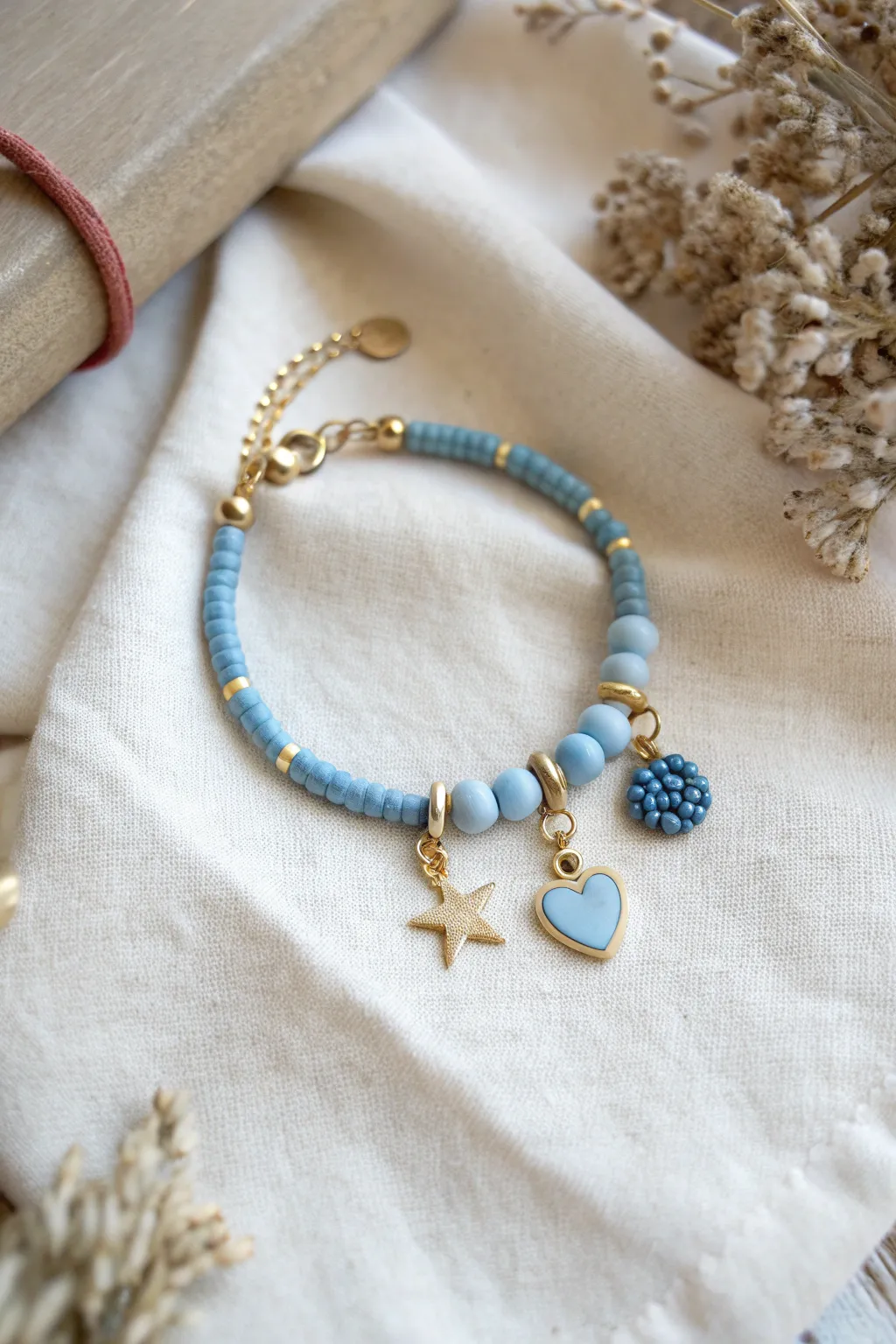 Minimal blue clay bracelet with a charm cluster accent for an easy, boho-scandi finish.