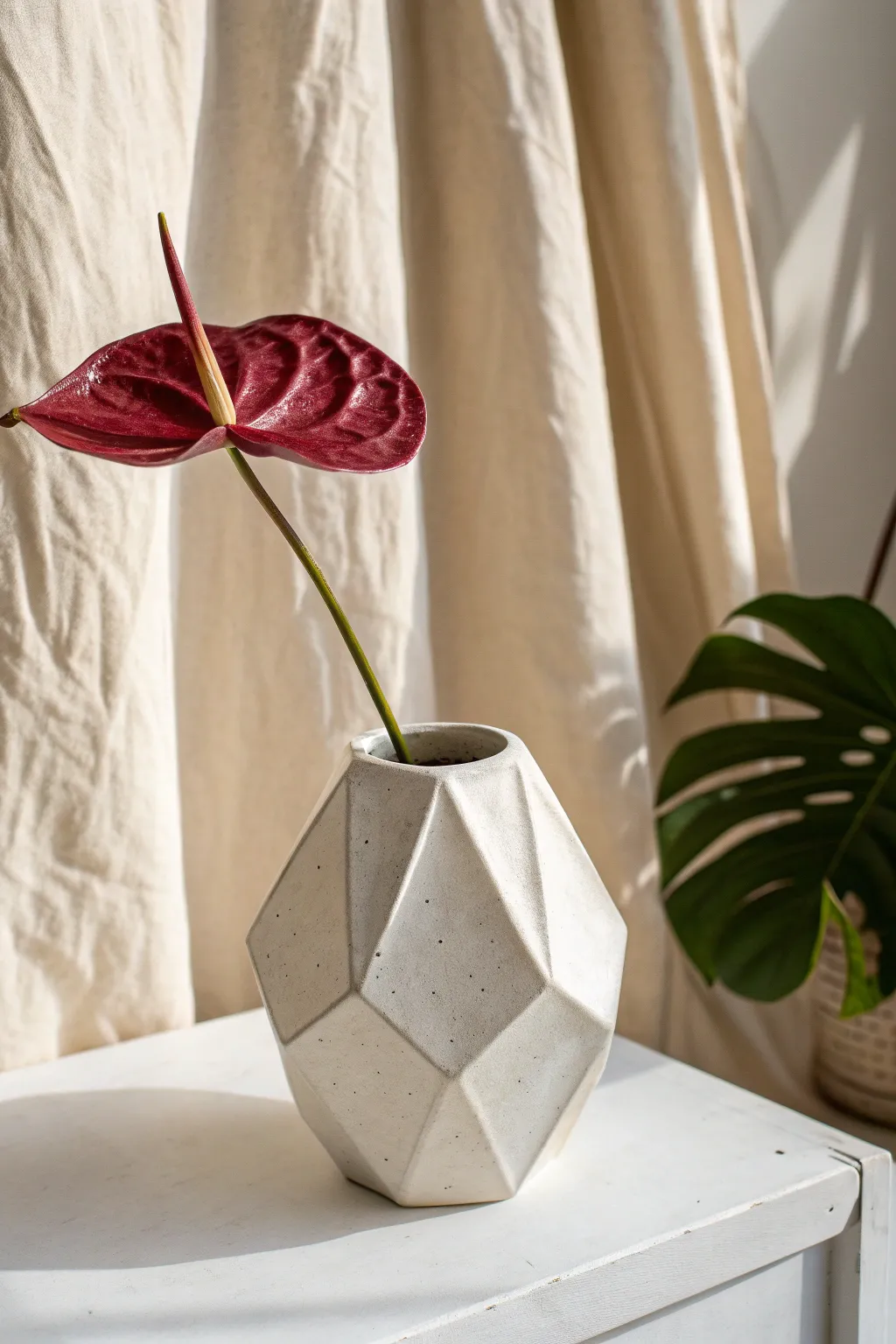 Crisp faceted slab vase with a single bold stem for modern, minimalist contrast