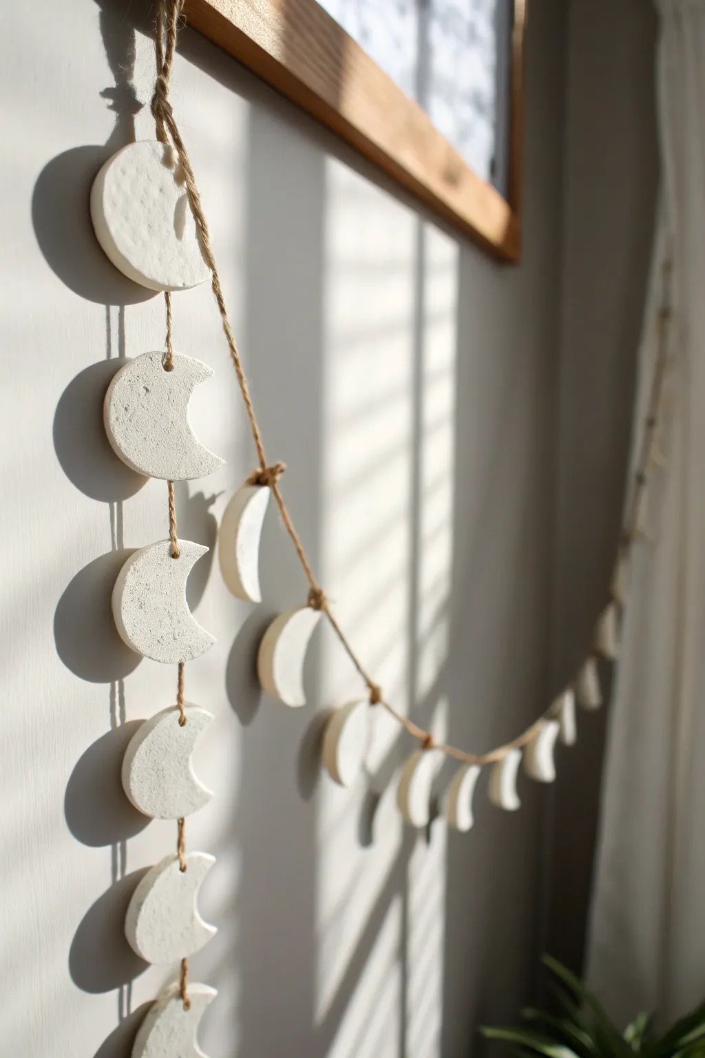 Minimal moon phase clay garland in matte white, a calming boho accent for any wall.