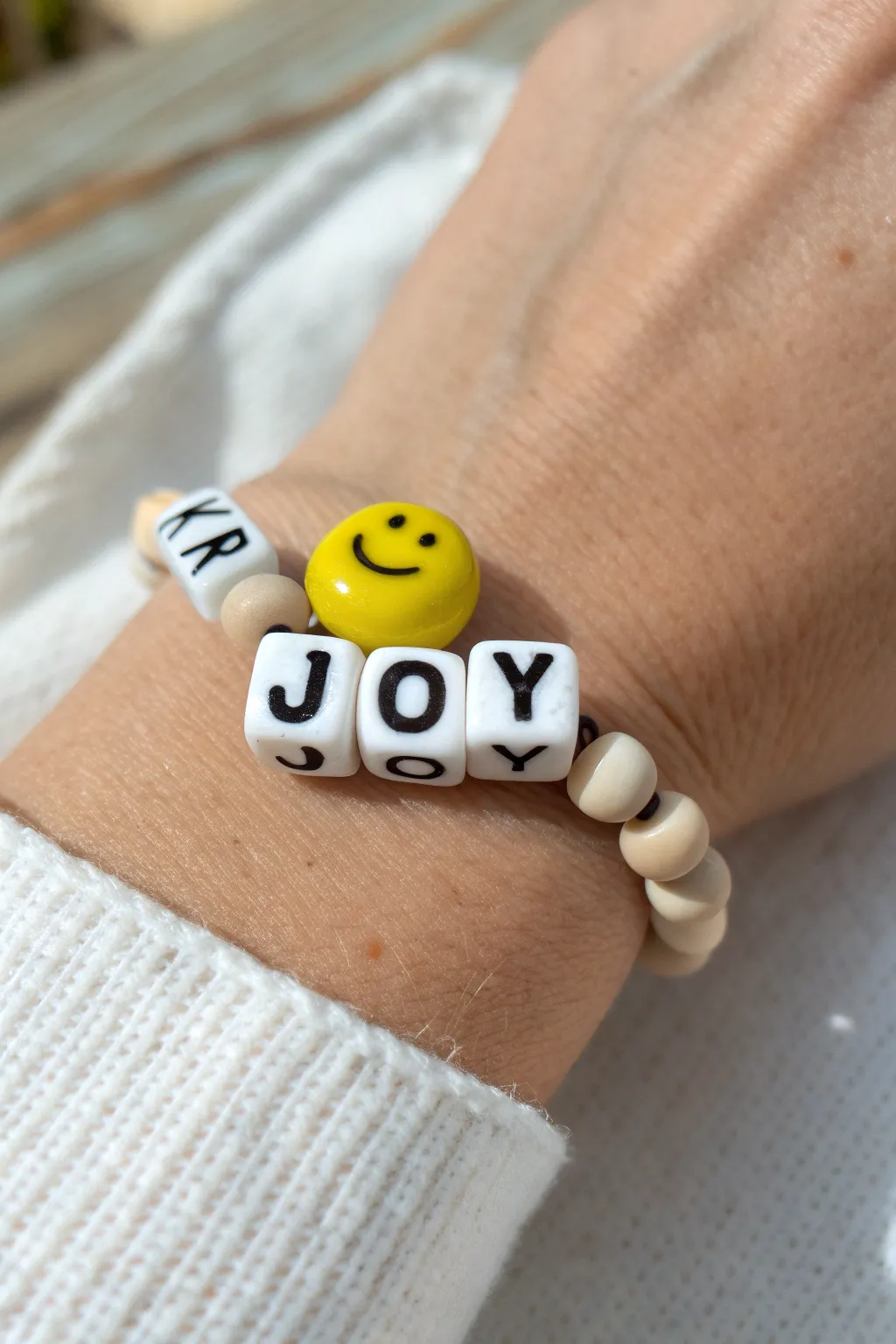 DIY clay bead bracelet with a sunny smiley and a tiny JOY message, minimalist Scandinavian-boho style.