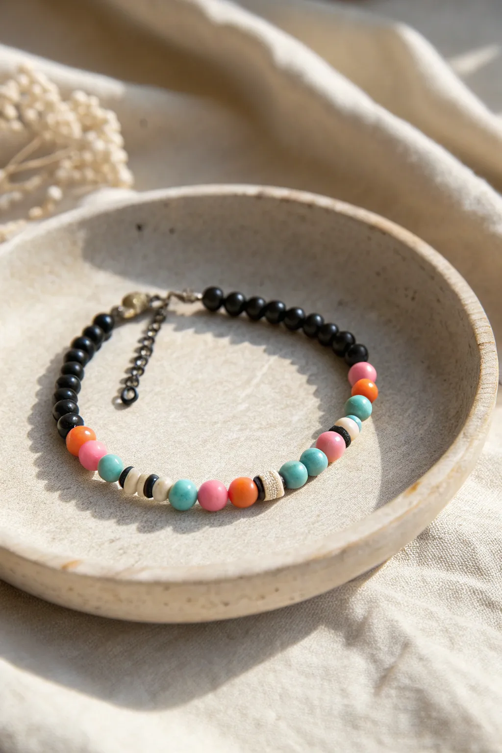 Tiny black bead spacers break up bold pink, orange, and turquoise clusters for clean contrast.