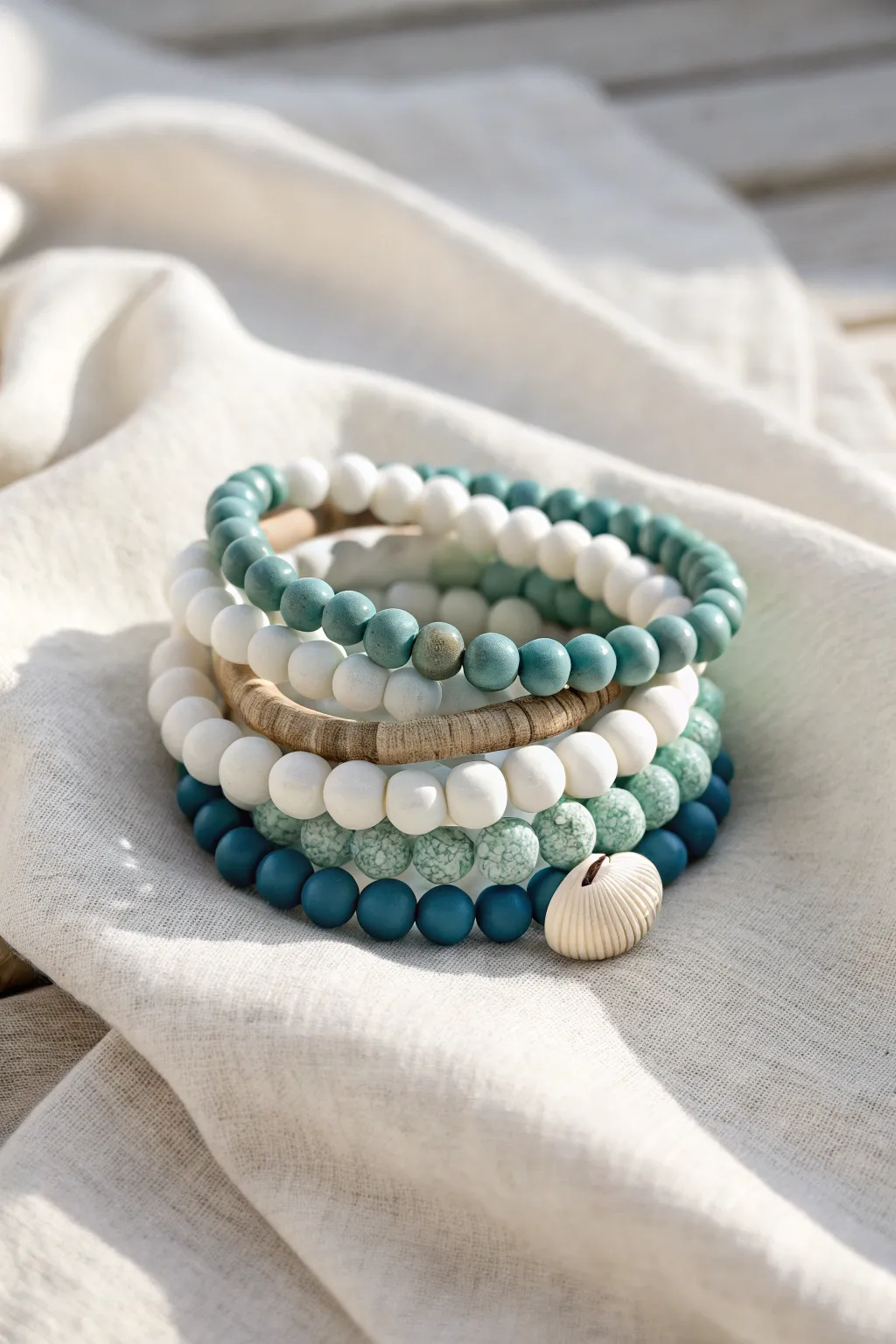 Beachy clay bracelet stack in ocean hues with a tiny shell bead for effortless coastal vibes