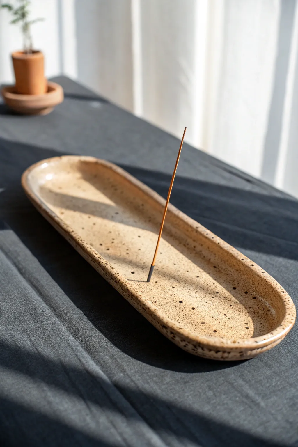 Wavy handmade clay incense tray in warm sand tones, minimalist Scandinavian style with boho calm.