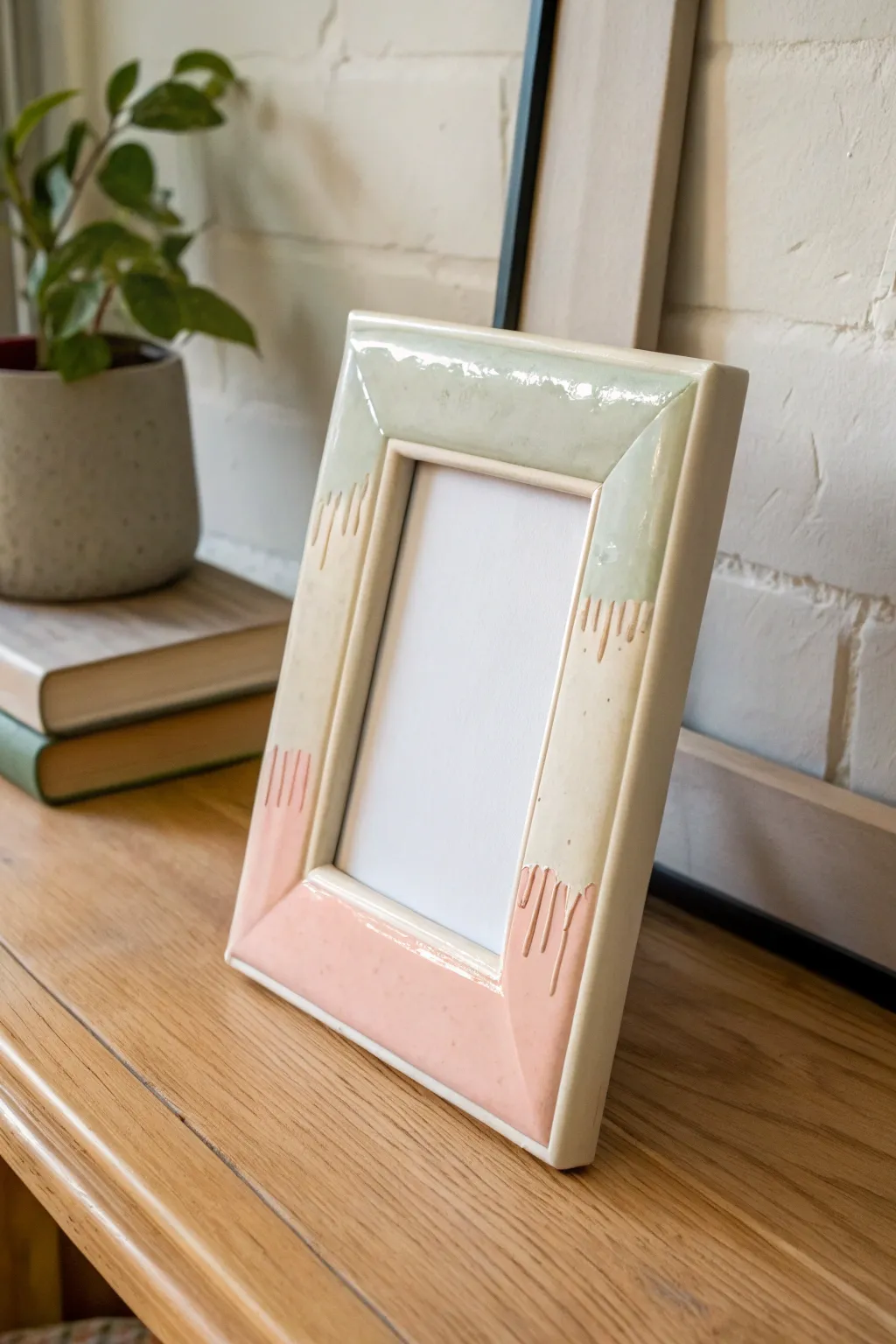 Handmade clay frame with faux glossy glaze drips, minimalist Scandi styling, high contrast light.