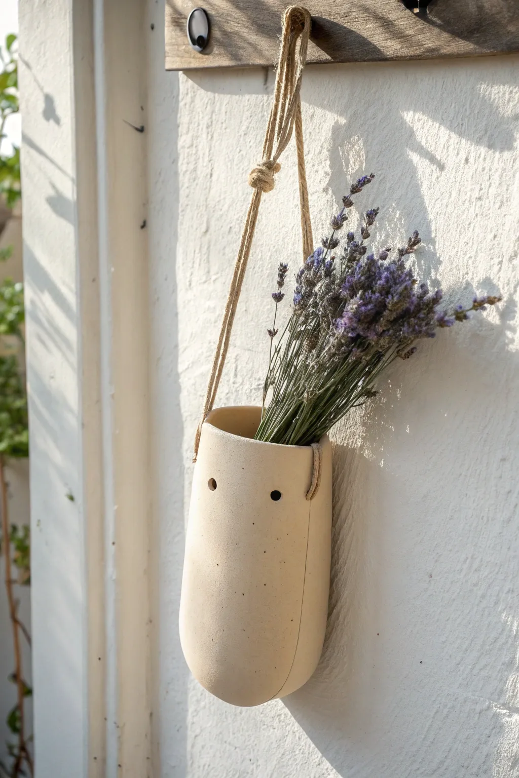 Minimal clay wall pocket with jute loop, holding a tiny dried sprig, calm boho vibe.