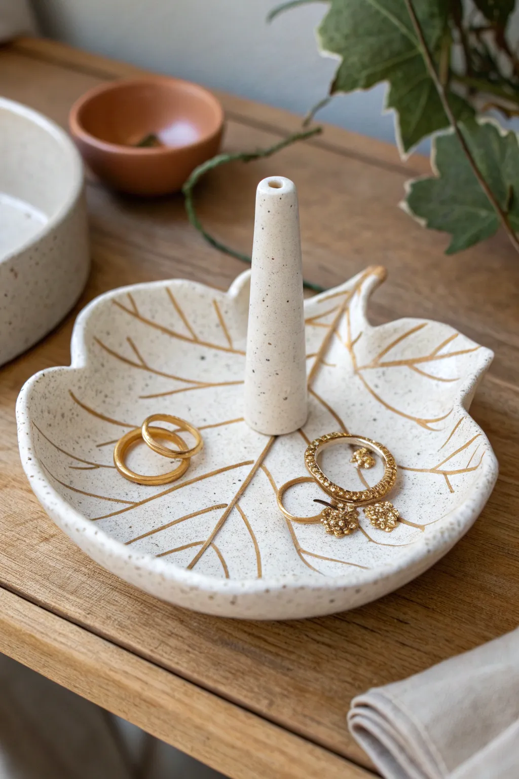 Minimal leaf-shaped ceramic ring holder with a stem post, perfect for rings and tiny studs.