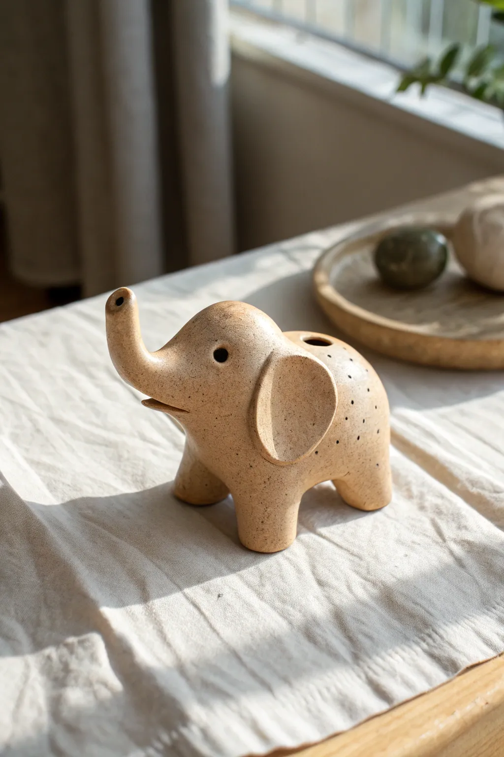 Minimalist elephant clay whistle with trunk mouthpiece, a cute handmade sound-maker for beginners.