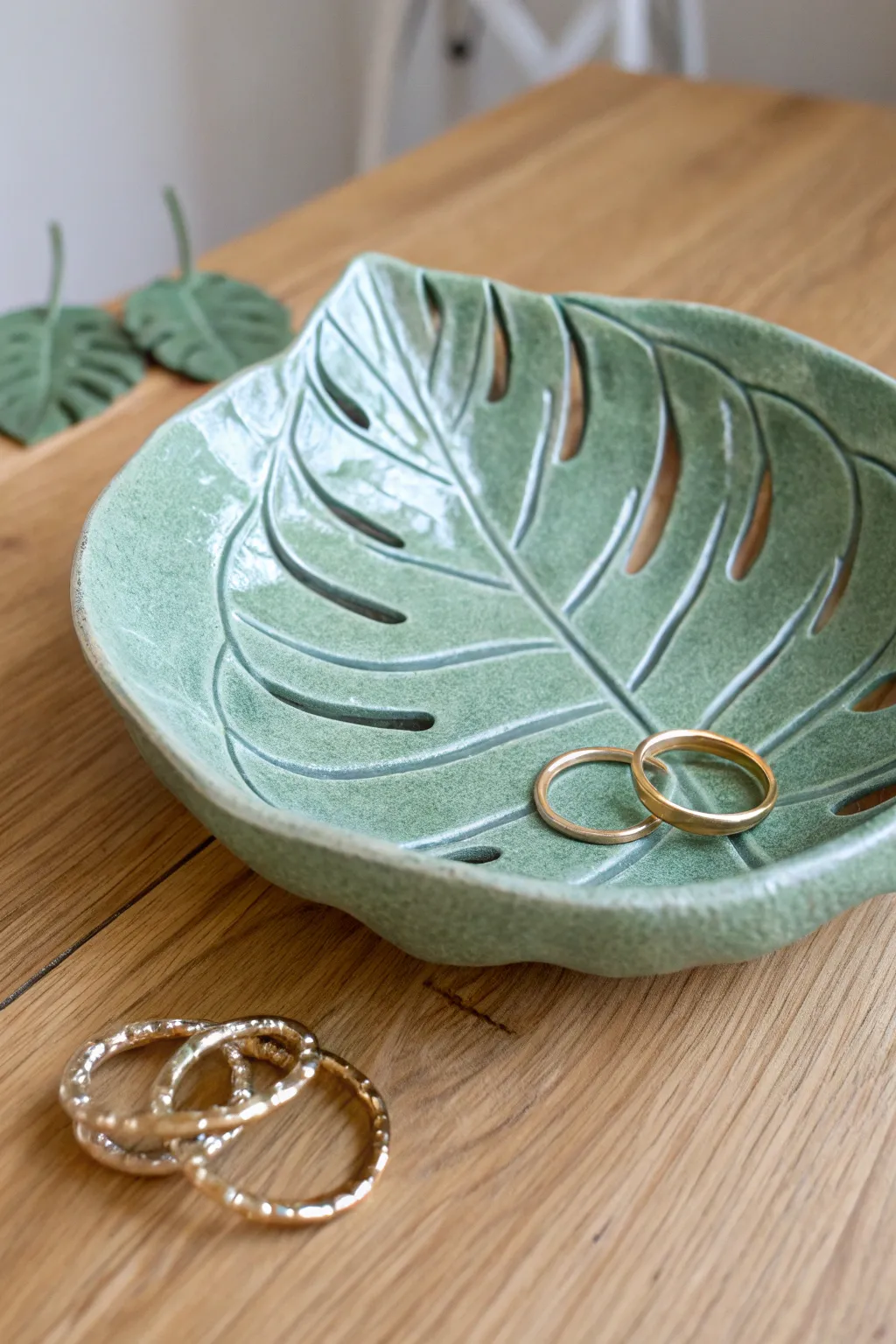 Monstera leaf catchall bowl in fresh green, perfect for rings and pins on warm wood.