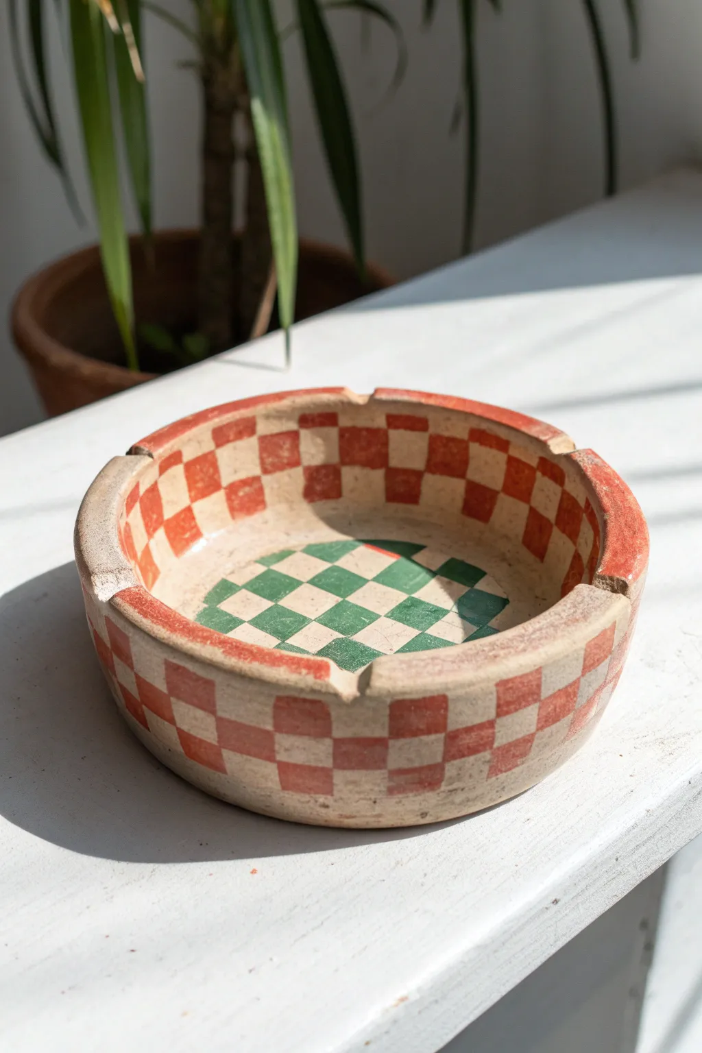 Bold checkerboard clay ashtray in coral and sage, minimalist styling with a soft boho vibe.