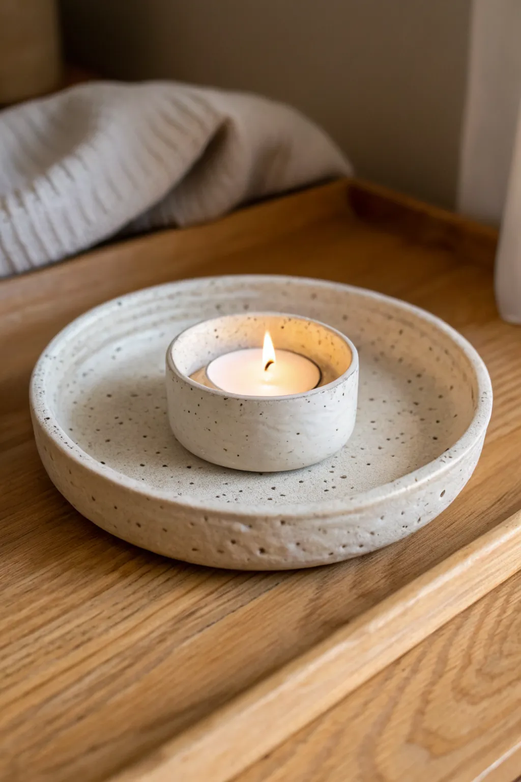 Mini clay candle holder dish with simple dots and warm evening light for cozy minimal decor