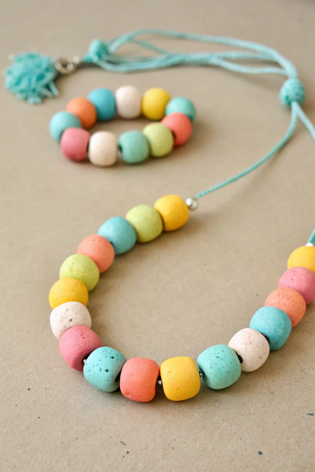 Chunky rainbow clay bead bracelet with matching necklace, a simple kids craft with big beads.