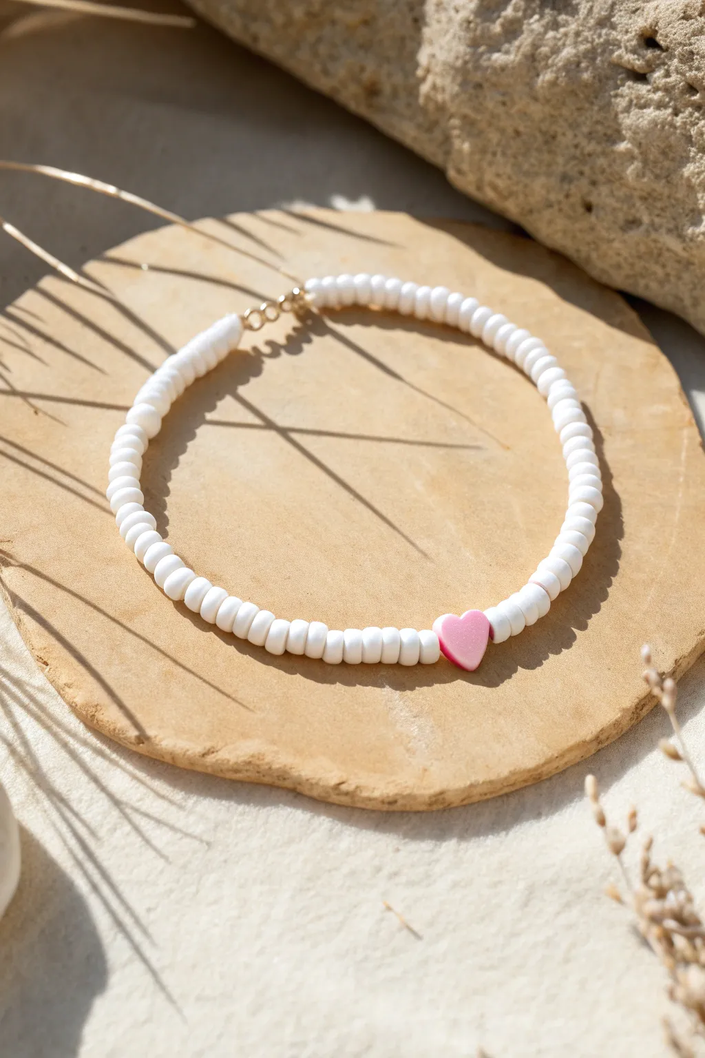 All-white heishi bracelet with one tiny heart bead accent in the center for a fresh, sweet look