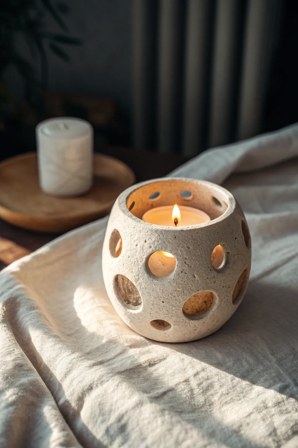 Handmade clay candle holder with glowing cutouts, cozy minimalist styling for soft evenings.