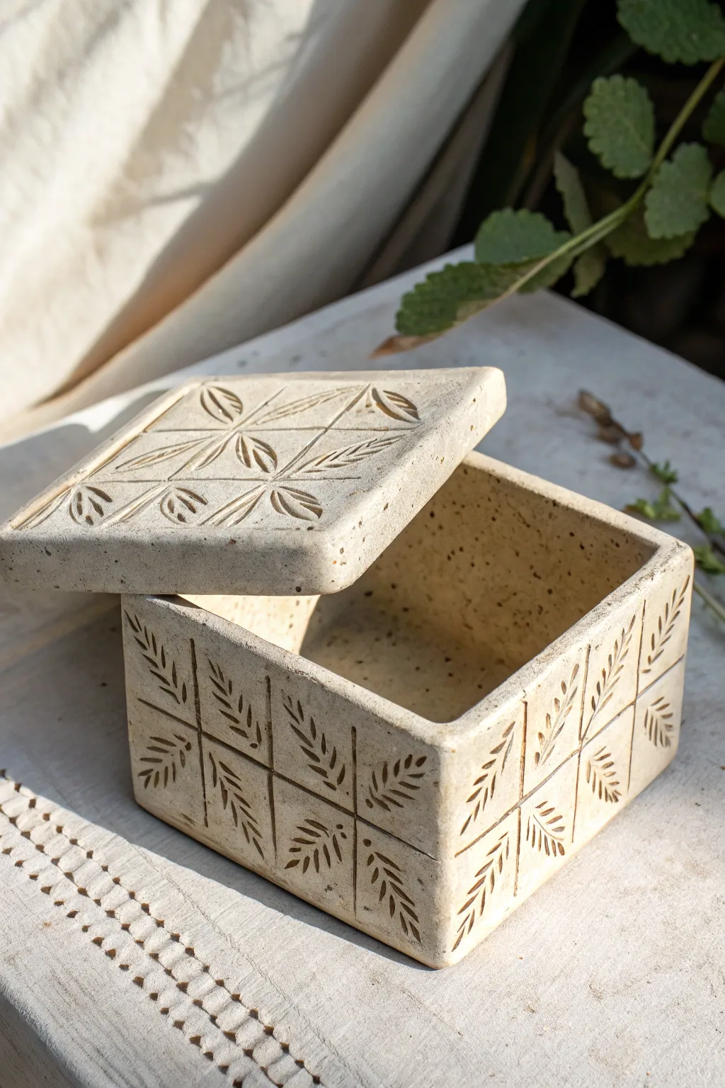 Stamped slab treasure box with a peek inside, simple patterns and crisp edges in warm stoneware.