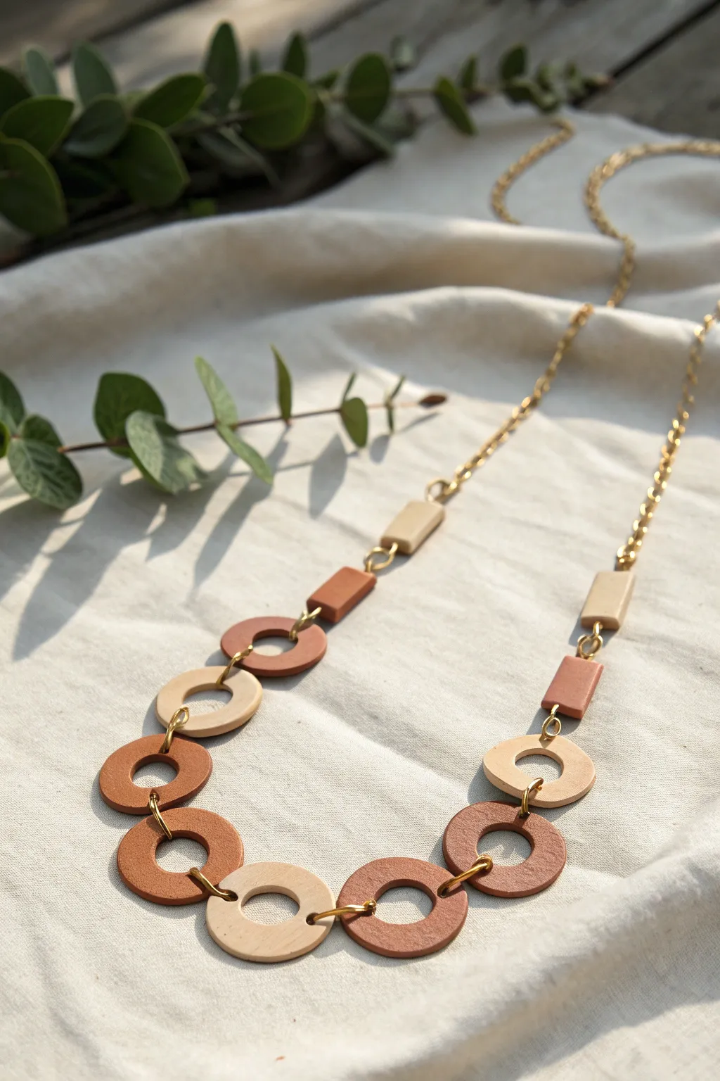 Graphic arch and half-moon polymer clay links for a clean, modern necklace with boho warmth.