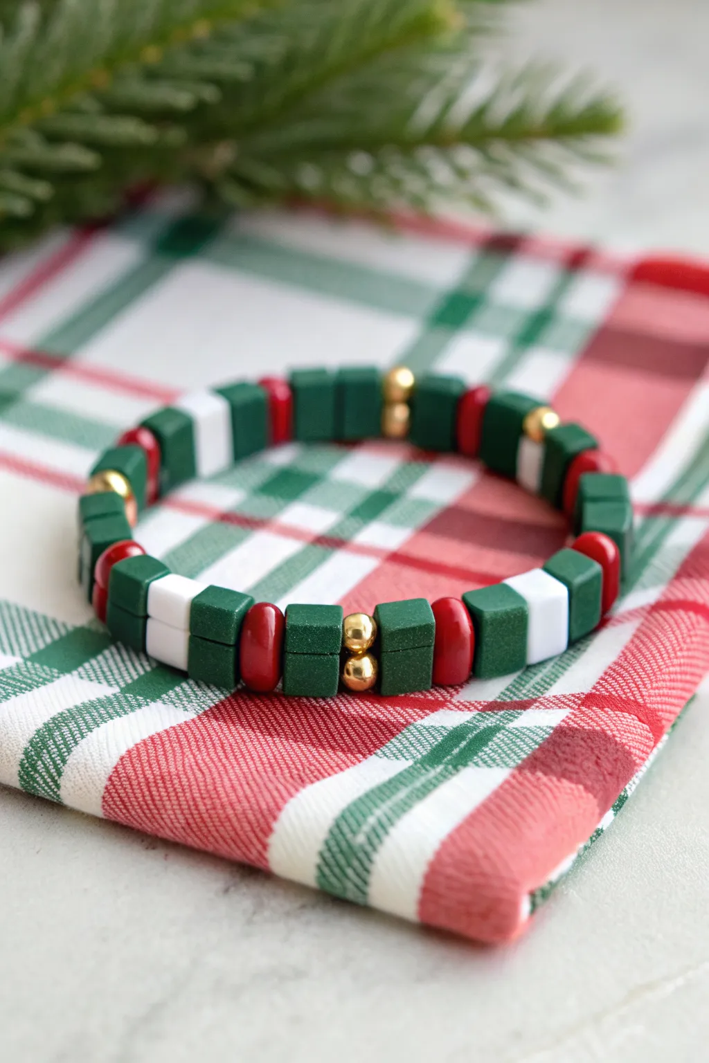 Preppy plaid-inspired clay bead bracelet with green, red, white bands and gold spacers