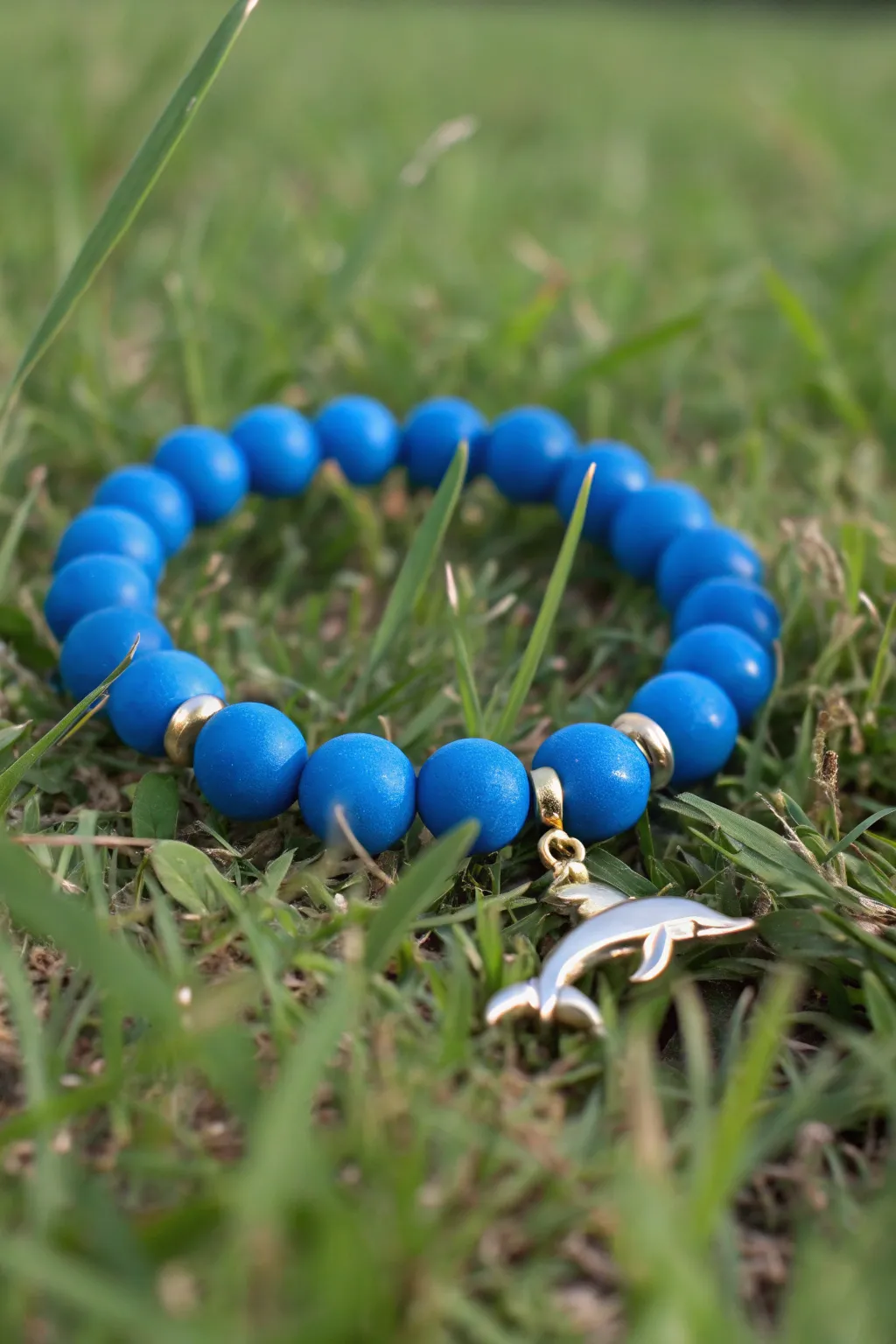 Bright blue clay bead bracelet with a simple dolphin charm for an easy preppy sea-life accent