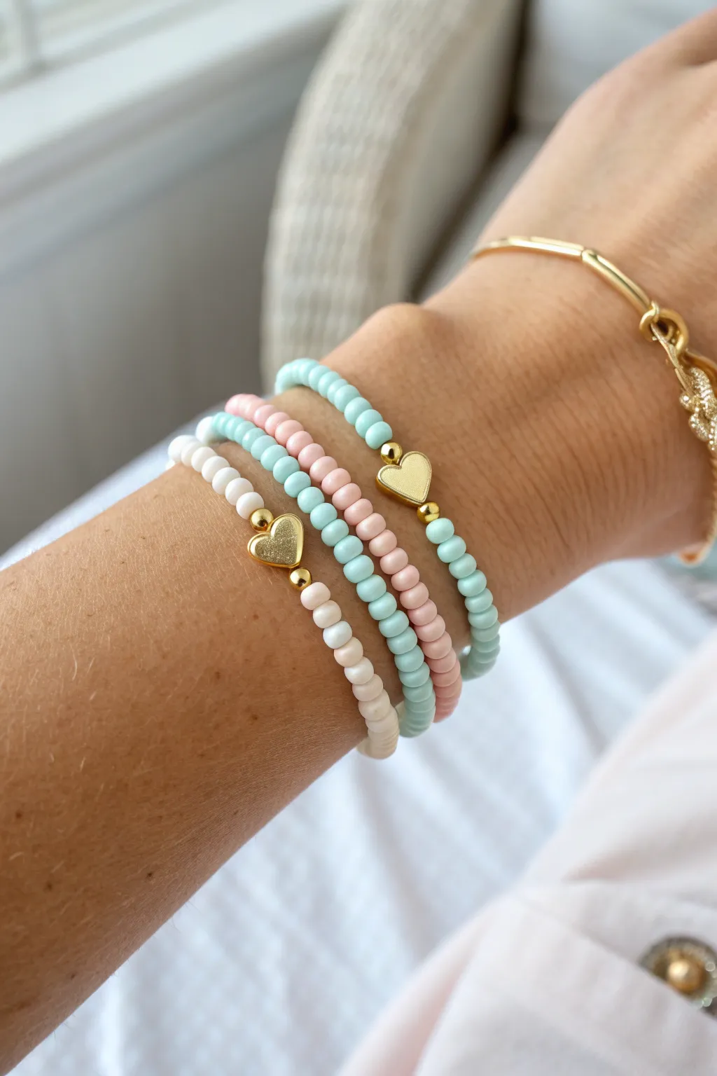Preppy clay heishi stack with heart charm stations, clean minimalist styling for everyday wear.