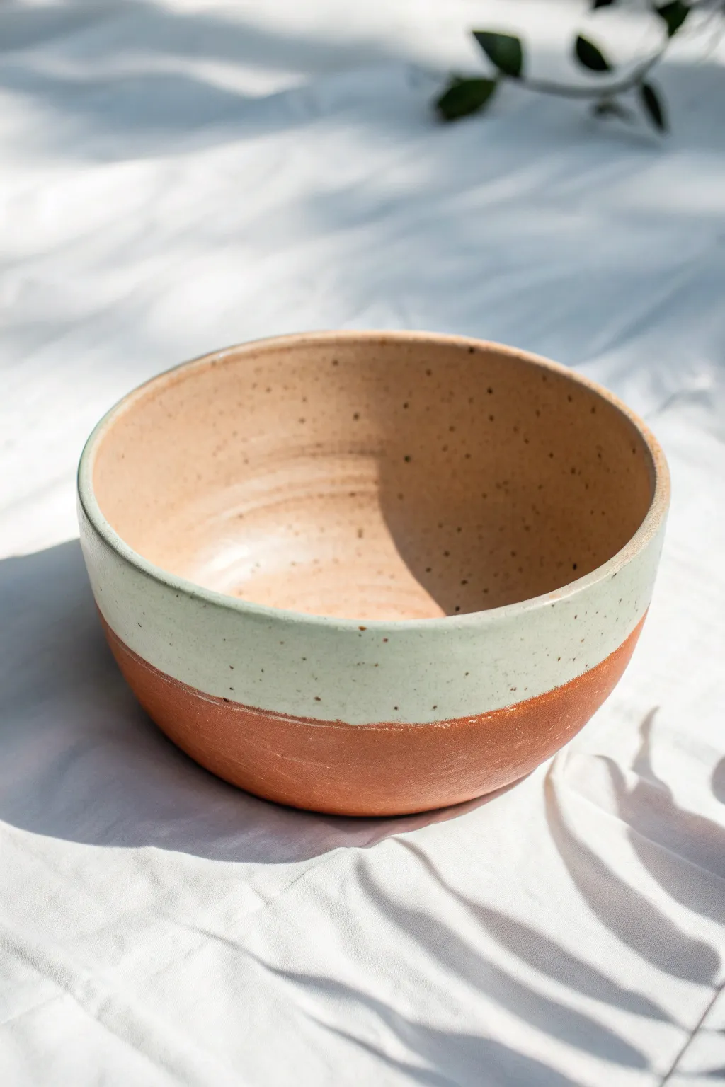 Half-dipped two-tone clay bowl: natural terracotta top, soft sage base, clean and minimal.