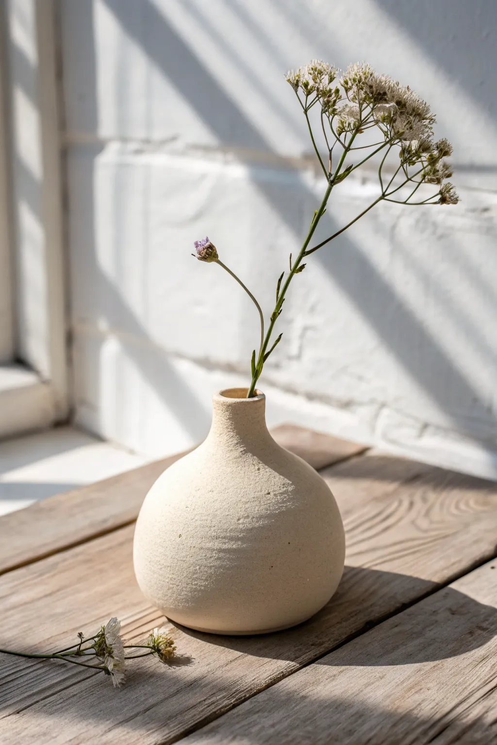 Tiny air-dry clay bud vase for summer, minimalist and boho, softly lit with a single bloom.
