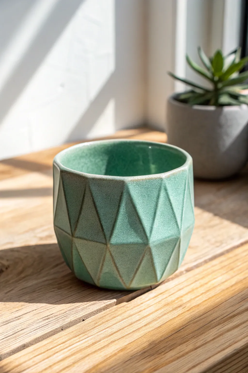 Faceted handmade tea cup, single-tone glaze letting crisp planes catch the morning light