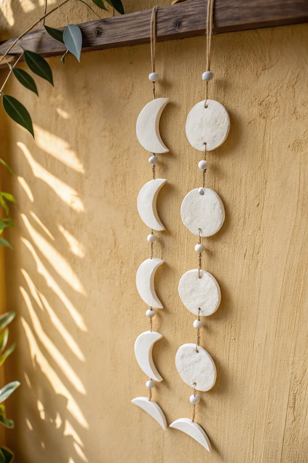 Minimal moon phase wall hanging in matte white air dry clay, soft boho warmth and clean lines