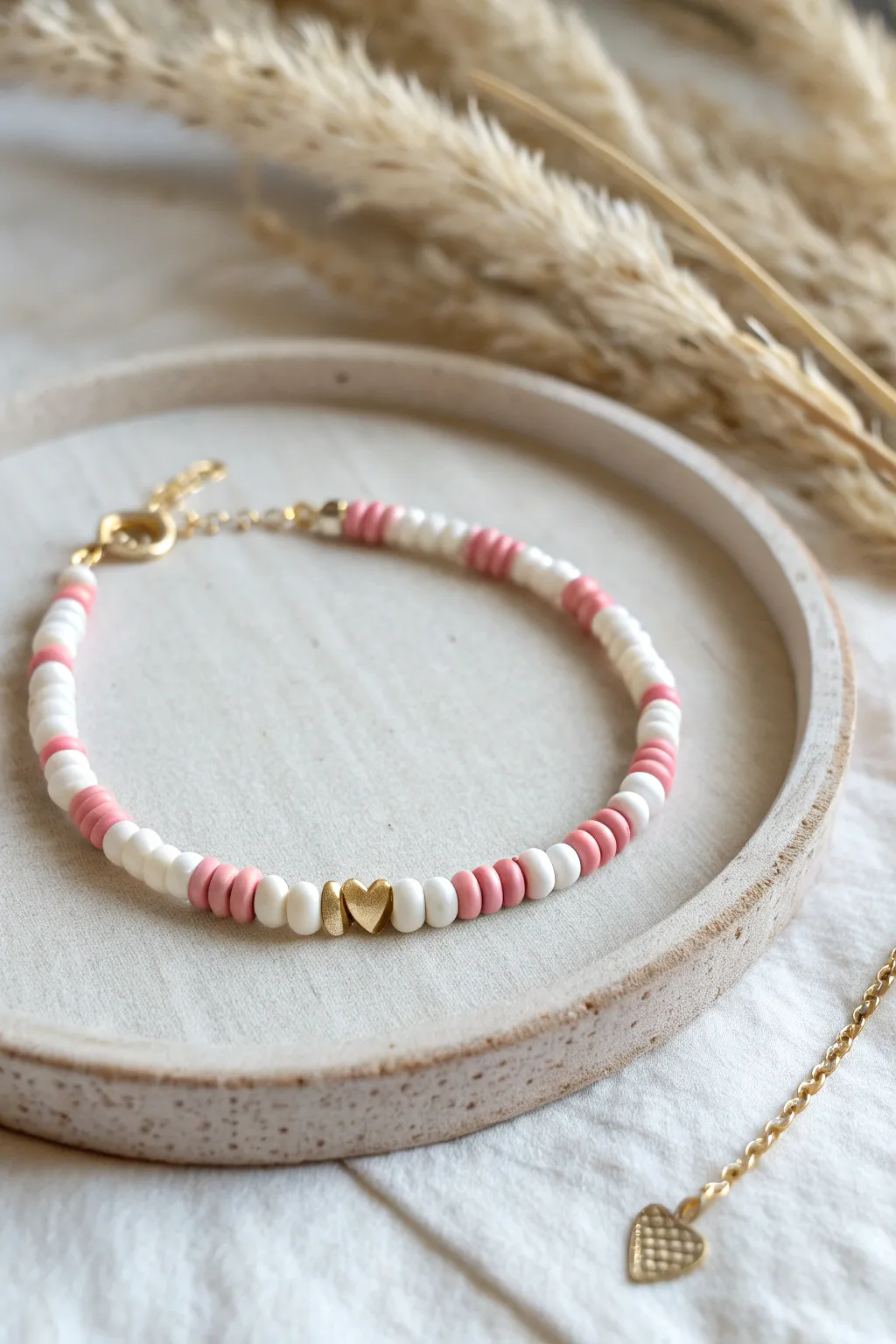 Tiny heart beads alternating with blush and white heishi for a sweet minimalist repeat